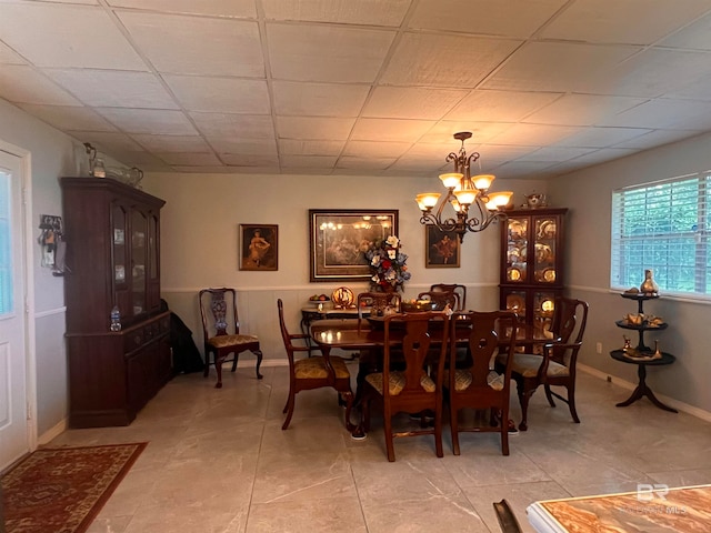 dining space with a chandelier, light tile patterned floors, and a paneled ceiling