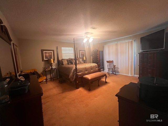 bedroom featuring carpet flooring, ceiling fan, and a textured ceiling