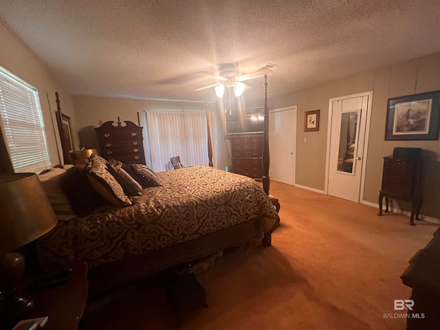 bedroom with ceiling fan, carpet floors, and a textured ceiling