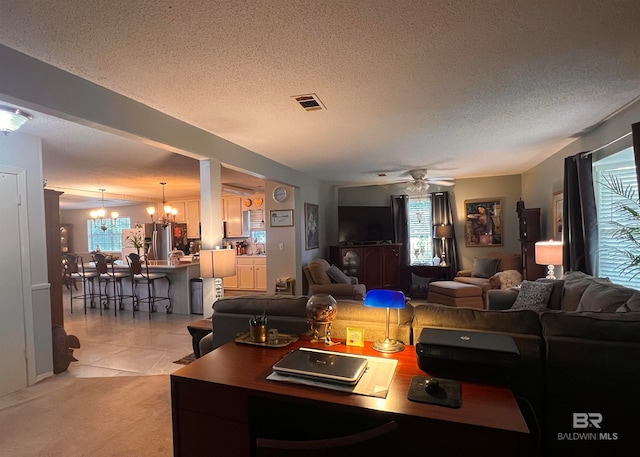 carpeted living room featuring ceiling fan with notable chandelier and a textured ceiling