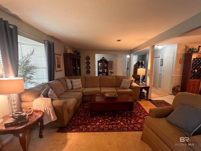 carpeted living room featuring a textured ceiling