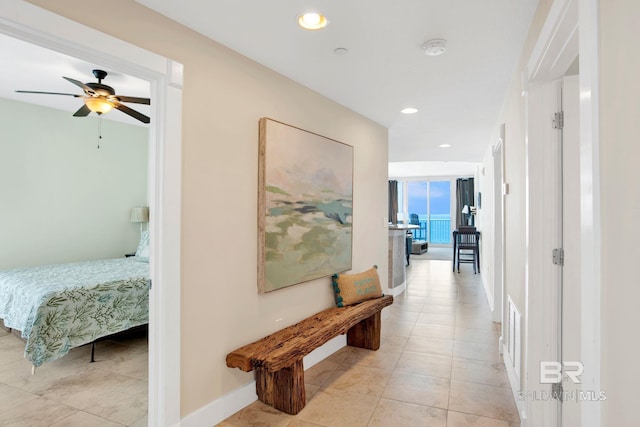 corridor with light tile patterned flooring, recessed lighting, and baseboards
