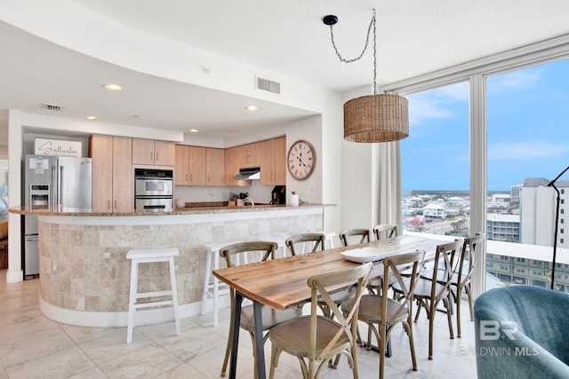 dining room featuring expansive windows, recessed lighting, and light tile patterned floors