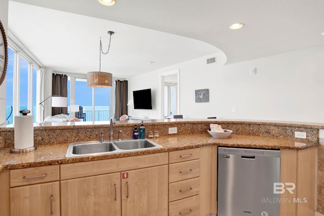 kitchen featuring light brown cabinetry, dishwasher, a sink, open floor plan, and recessed lighting
