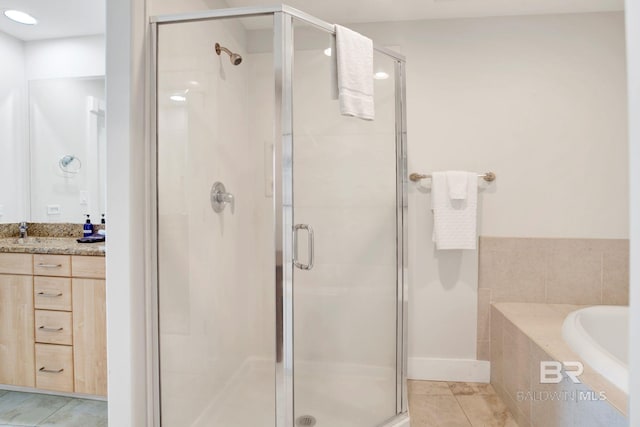 full bathroom with a stall shower, tile patterned flooring, vanity, and a bath