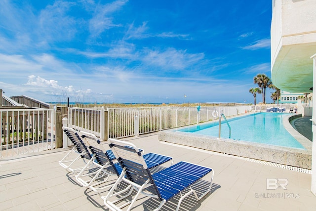 community pool with a patio and fence
