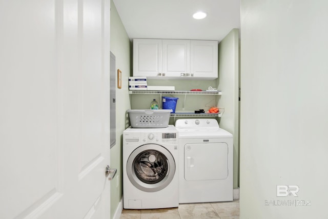laundry area with washing machine and dryer, cabinet space, and light tile patterned flooring