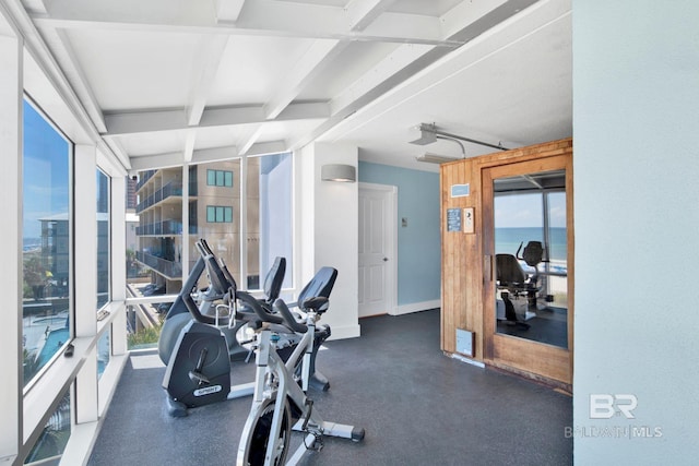 workout area featuring beam ceiling