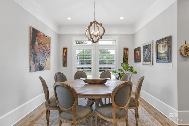 dining area featuring crown molding, a chandelier, and light wood-type flooring