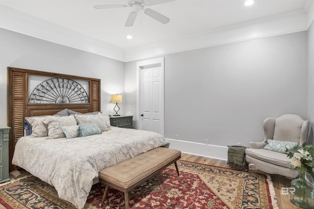 bedroom featuring hardwood / wood-style flooring, ornamental molding, and ceiling fan