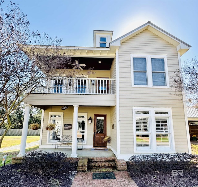 view of front of home with ceiling fan, a porch, and a balcony