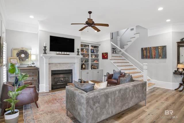 living room with crown molding, ceiling fan, and light hardwood / wood-style floors