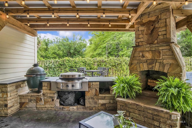 view of patio / terrace with grilling area and an outdoor stone fireplace