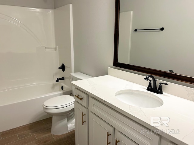 full bathroom featuring vanity, bathtub / shower combination, hardwood / wood-style flooring, and toilet