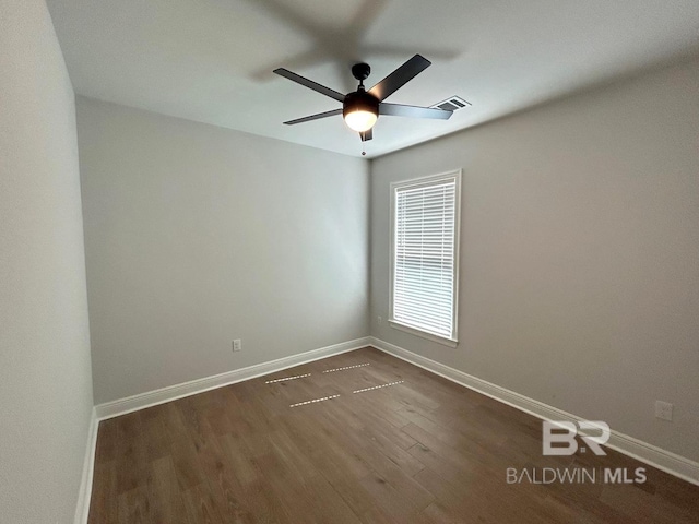 spare room with dark wood-type flooring and ceiling fan