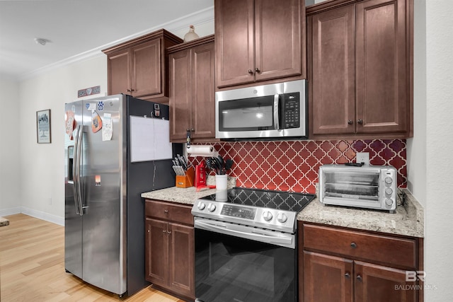 1246 Pembroke Way, Foley, AL 36535 - kitchen featuring appliances with stainless steel finishes, backsplash, light wood-style flooring, light stone counters, and crown molding