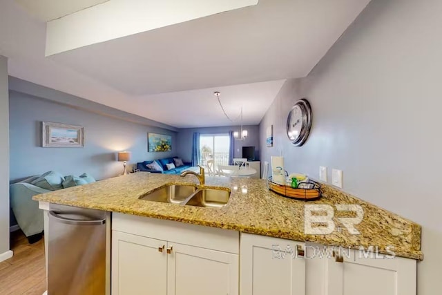 kitchen featuring white cabinets, light stone countertops, sink, kitchen peninsula, and light wood-type flooring