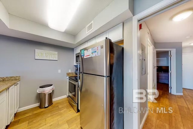 kitchen featuring white cabinets, stainless steel appliances, and light hardwood / wood-style floors