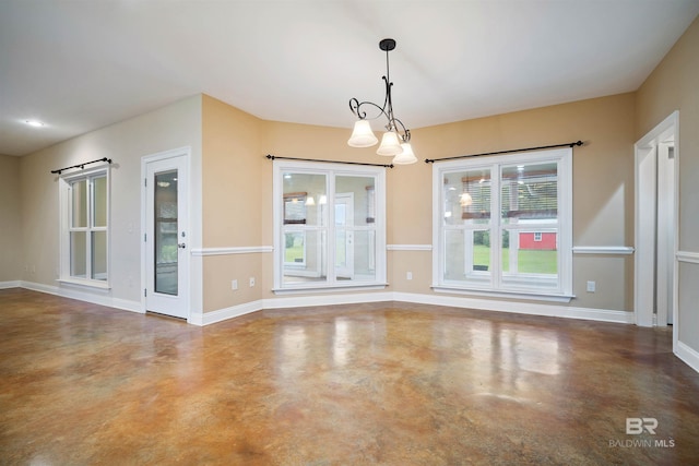 interior space with concrete flooring and an inviting chandelier