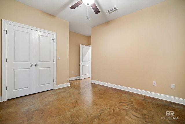 unfurnished bedroom featuring concrete flooring, ceiling fan, and a closet