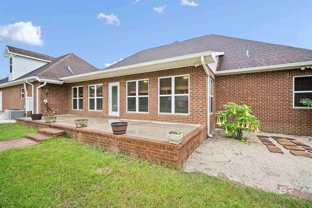 rear view of house featuring central AC unit, a yard, and a patio area