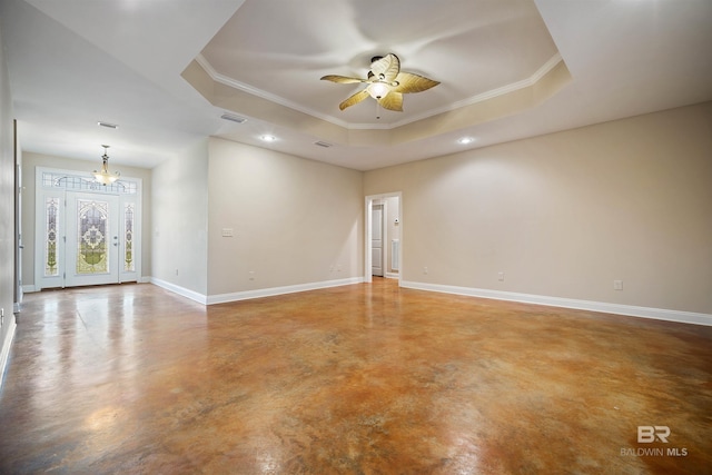 unfurnished room featuring ceiling fan with notable chandelier, concrete floors, a raised ceiling, and crown molding