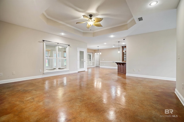 unfurnished living room featuring a tray ceiling, ornamental molding, and ceiling fan with notable chandelier