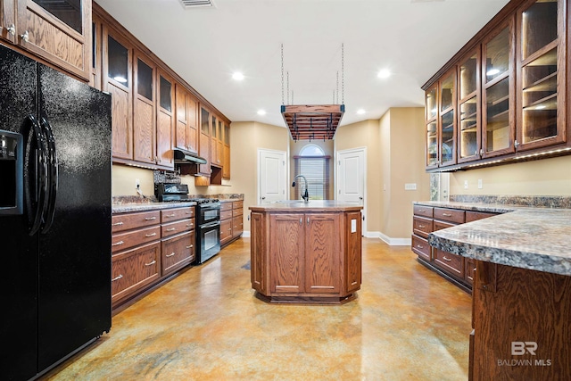 kitchen featuring black appliances, sink, and a center island with sink