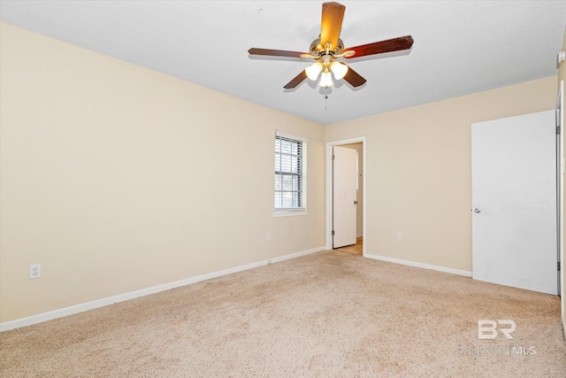 empty room featuring light carpet, a ceiling fan, and baseboards