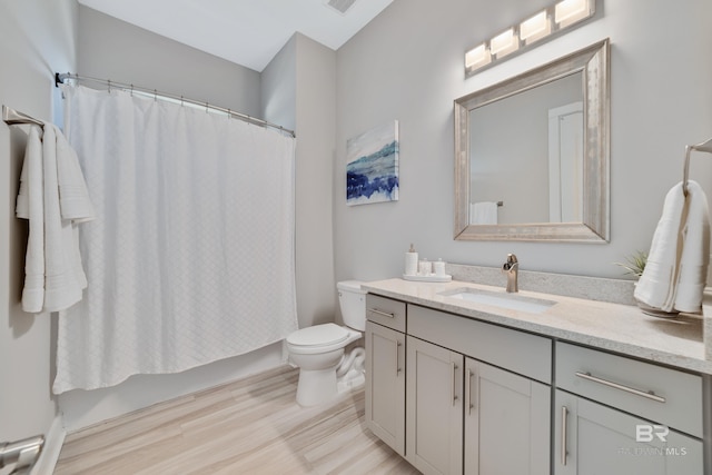 3214 Dolphin Dr, Gulf Shores, AL 36542 - bathroom with vanity, visible vents, toilet, wood finished floors, and shower / tub combo with curtain