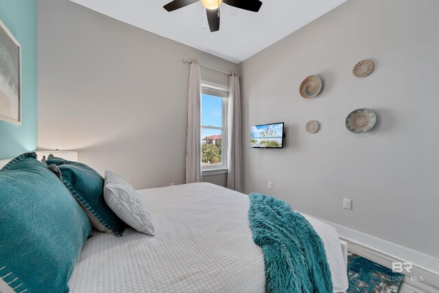 3214 Dolphin Dr, Gulf Shores, AL 36542 - bedroom with wood finished floors, ceiling fan, and baseboards