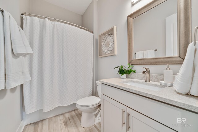 3214 Dolphin Dr, Gulf Shores, AL 36542 - full bath featuring toilet, shower / bath combo with shower curtain, vanity, and wood finished floors
