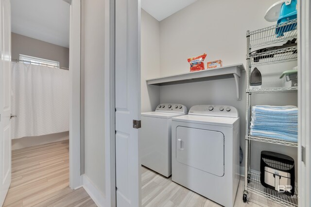 3214 Dolphin Dr, Gulf Shores, AL 36542 - laundry room featuring baseboards, light wood-type flooring, laundry area, and washing machine and clothes dryer