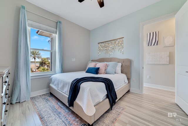 3214 Dolphin Dr, Gulf Shores, AL 36542 - bedroom featuring light wood-style flooring, a ceiling fan, and baseboards