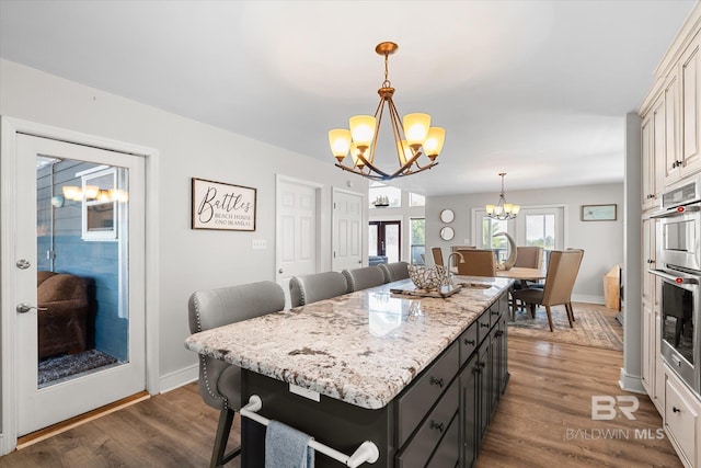 kitchen with wood-type flooring, pendant lighting, sink, and a center island