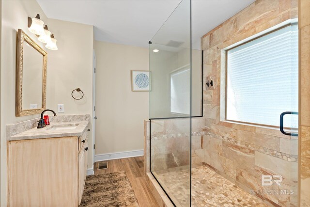 bathroom with an enclosed shower, plenty of natural light, hardwood / wood-style flooring, and vanity