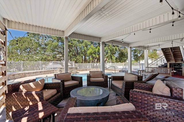 view of patio / terrace with a fenced in pool and an outdoor living space with a fire pit