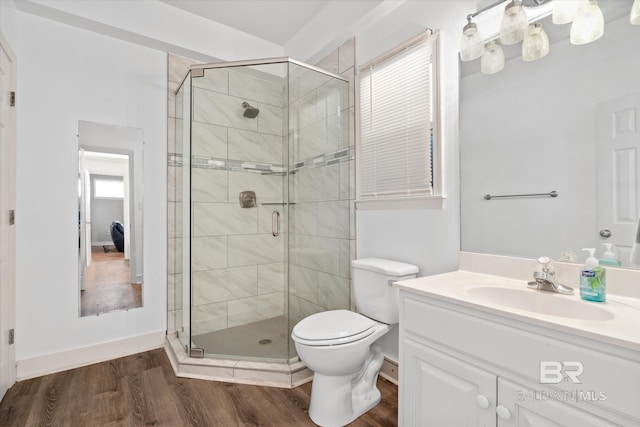 bathroom with an enclosed shower, wood-type flooring, vanity, and toilet