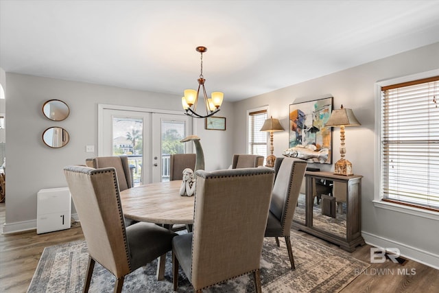 dining space featuring dark wood-type flooring, plenty of natural light, and french doors