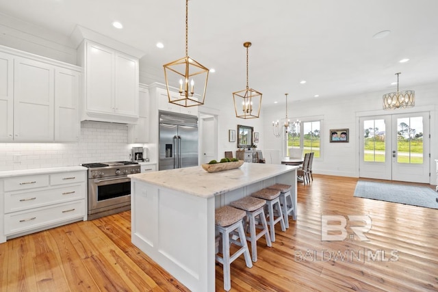 21151 Caveletti Cir, Fairhope, AL 36532 - kitchen with high quality appliances, a chandelier, light wood-style flooring, a center island, and recessed lighting