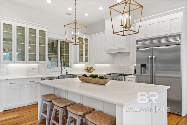 21151 Caveletti Cir, Fairhope, AL 36532 - kitchen with stainless steel built in refrigerator, a chandelier, white cabinetry, a center island, and recessed lighting