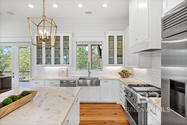 21151 Caveletti Cir, Fairhope, AL 36532 - kitchen with appliances with stainless steel finishes, tasteful backsplash, light wood-type flooring, white cabinetry, and recessed lighting