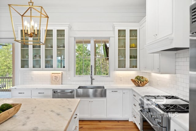 21151 Caveletti Cir, Fairhope, AL 36532 - kitchen with appliances with stainless steel finishes, a chandelier, white cabinets, and backsplash