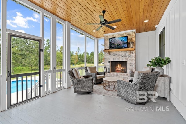 21151 Caveletti Cir, Fairhope, AL 36532 - sunroom / solarium with wooden ceiling, plenty of natural light, ceiling fan, a wall of windows, and an outdoor living space with a fireplace