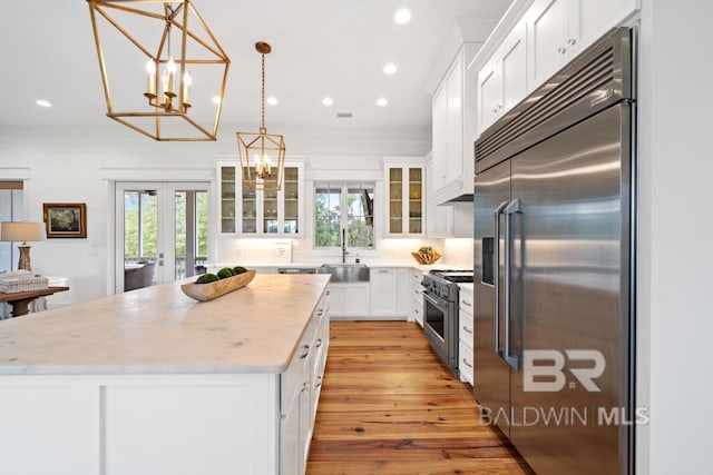 21151 Caveletti Cir, Fairhope, AL 36532 - kitchen featuring high quality appliances, french doors, a kitchen island, a chandelier, and white cabinetry