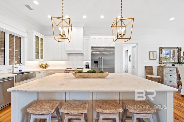 21151 Caveletti Cir, Fairhope, AL 36532 - kitchen featuring appliances with stainless steel finishes, a chandelier, a kitchen island, tasteful backsplash, and recessed lighting