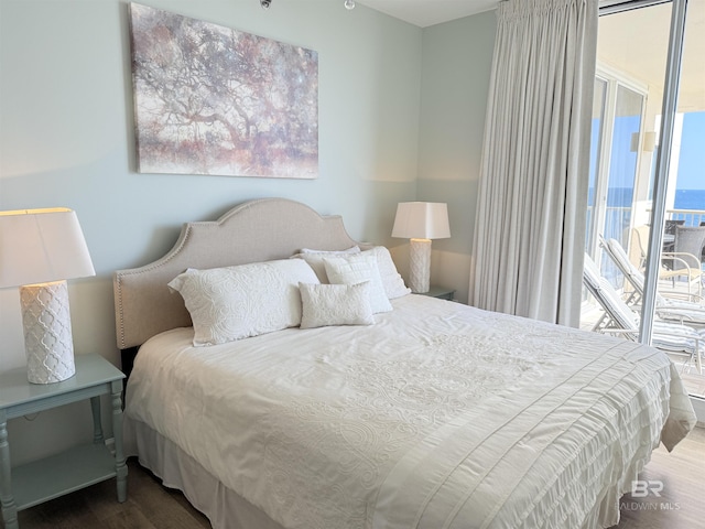 bedroom featuring access to outside and wood finished floors