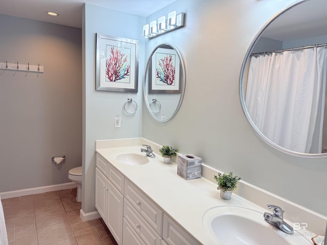 bathroom with toilet, a sink, tile patterned flooring, and baseboards