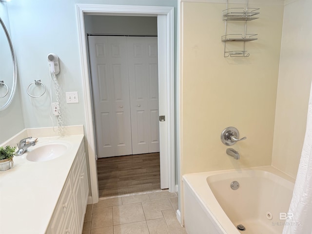 bathroom featuring tile patterned flooring, vanity, shower / bath combination with curtain, and a closet