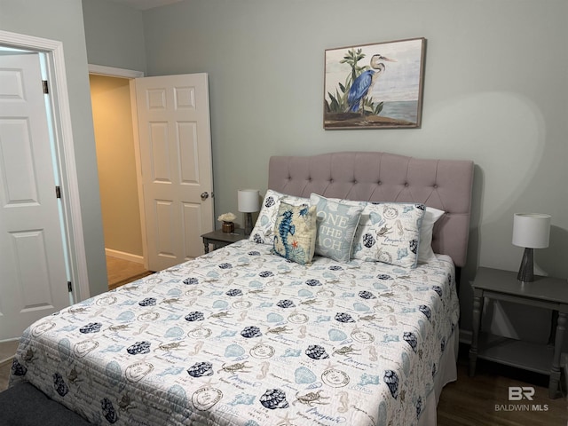 bedroom featuring wood finished floors and baseboards
